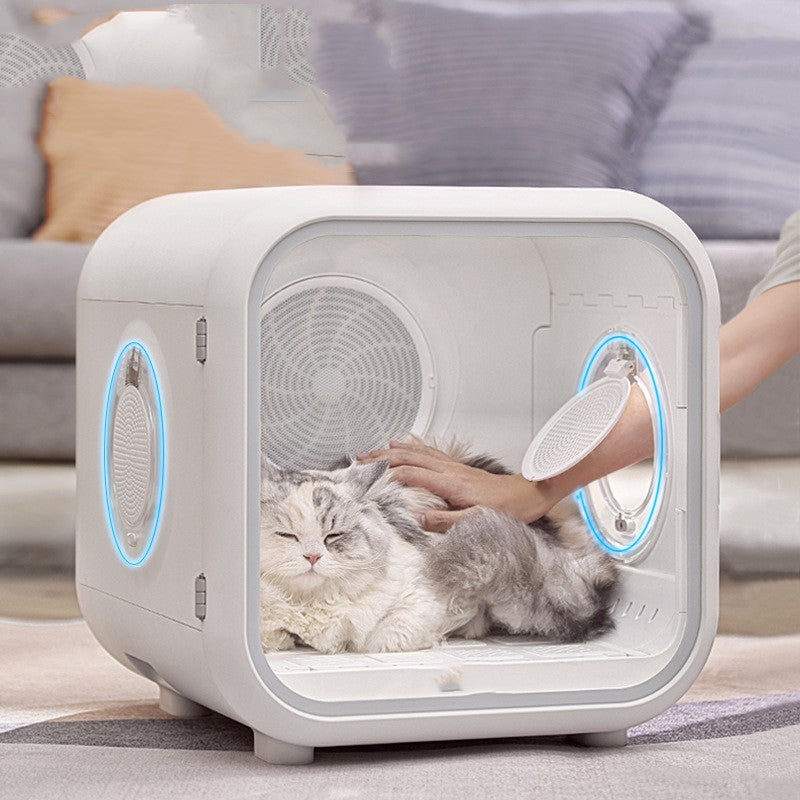 Cat Hair Dryer in a white enclosed drying box with rounded edges, vent fans and a clear front door, shown with a fluffy cat inside