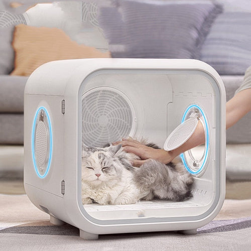 Cat Hair Dryer in a white enclosed drying box with rounded edges, vent fans and a clear front door, shown with a fluffy cat inside