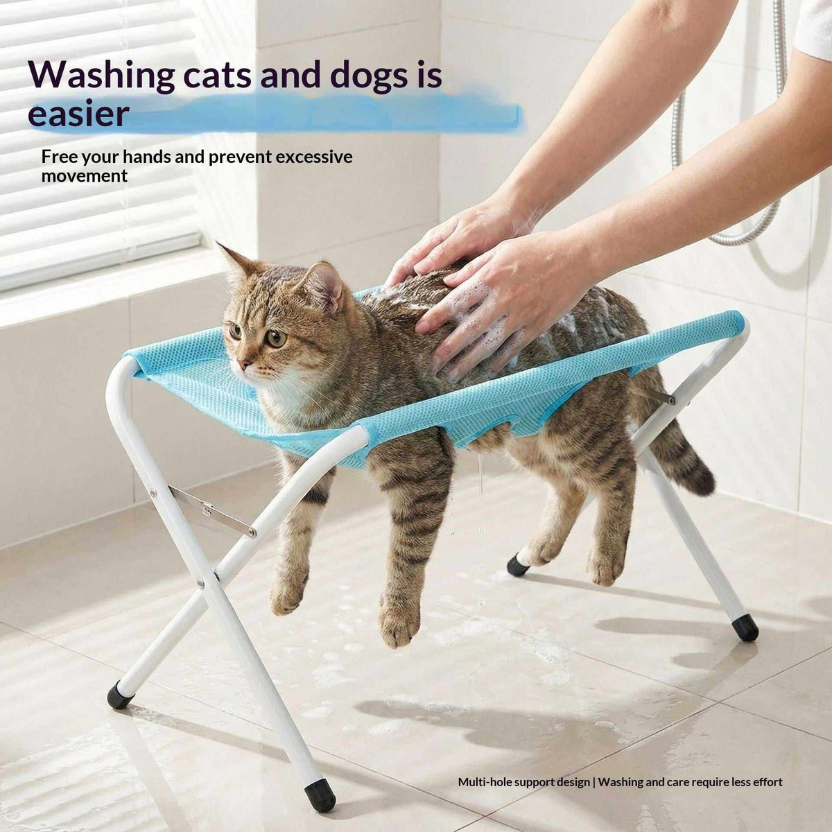 Foldable Pet Bathing Stand with a blue mesh hammock on a white folding frame, supporting a wet tabby cat during washing