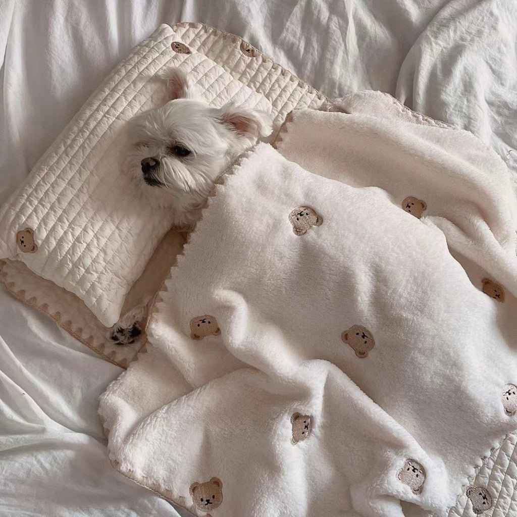 Removable And Washable Dog Bed in beige with quilted and soft fleece materials featuring a simple bear pattern, including a pillow and blanket